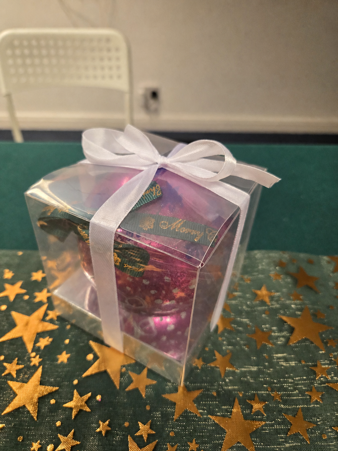 Decorated pink Christmas bauble presented in a clear gift box with a white ribbon