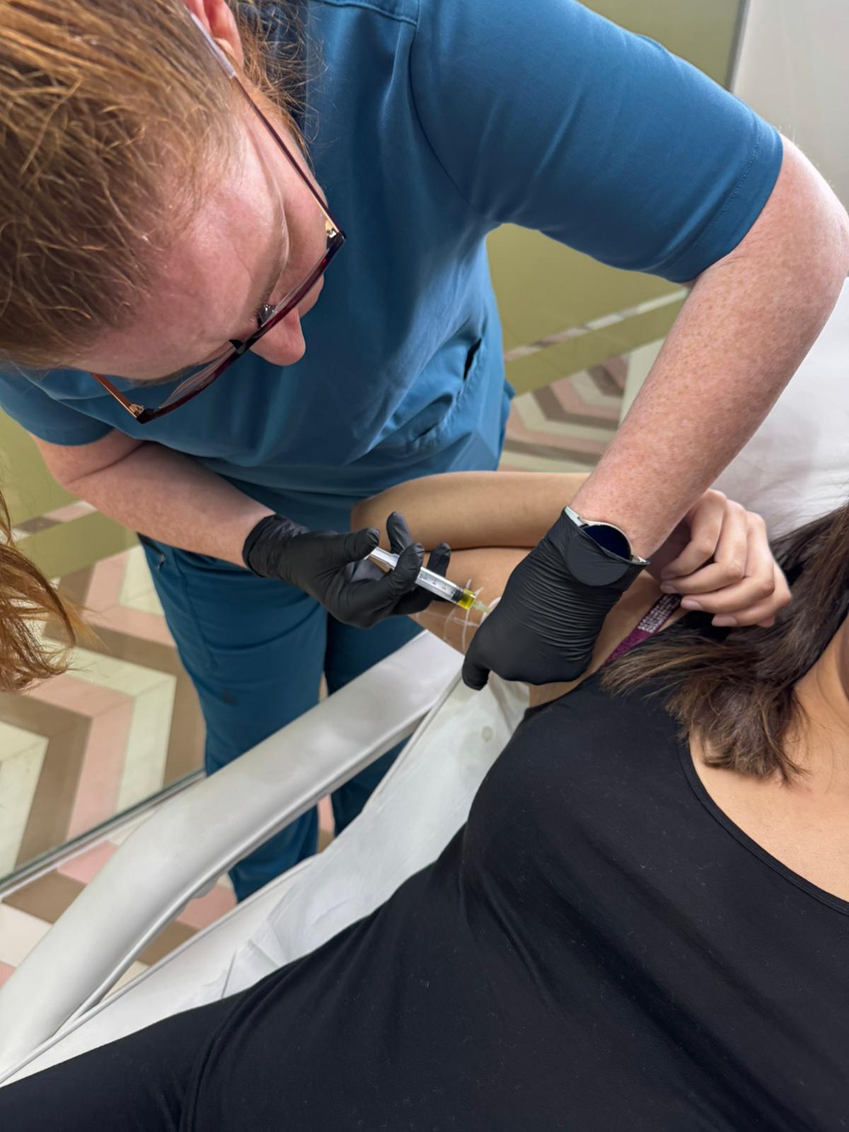 Advanced practitioner administering a fat dissolving treatment following consultation.